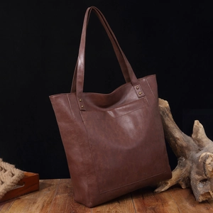 Vue détaillée d'un cabas en cuir marron vintage avec poche et décoration rustique