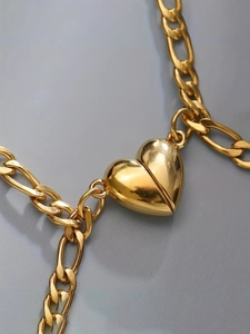 Macro shot of polished gold-tone heart pendant and Cuban link chain texture details