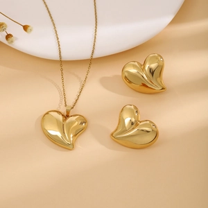 Detailed view of luxury gold heart necklace and earring set on elegant warm background
