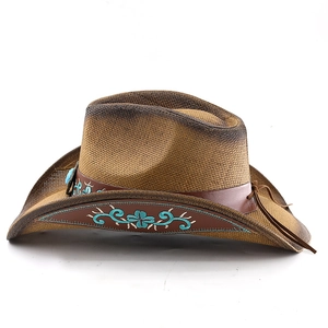 Close-up of Western straw cowboy hat with floral embroidery and leather tassel detail