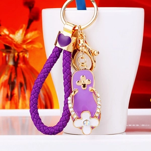 Macro detail of a purple flip-flop keychain with sparkling crystals on a woven strap