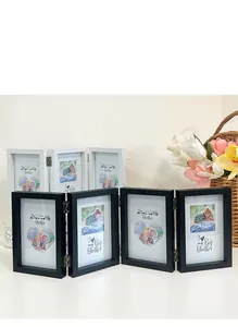 Detail of folding wooden photo frame with metal hinges and minimalist black and white finish