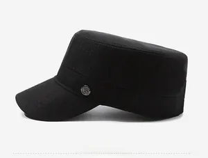 Close-up of black flat top military cap featuring a metallic K logo and cotton texture