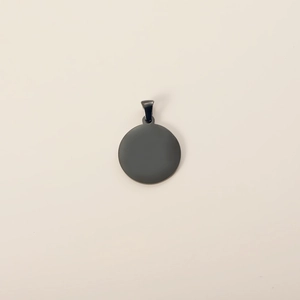 Close-up of a minimalist round black stainless steel pet ID tag with a polished finish