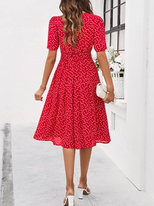 Vue arrière d'une robe mi-longue à pois rouges avec manches courtes et lien à la taille