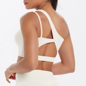 Detail of ivory single shoulder sports bra showing cross straps and cutout back design