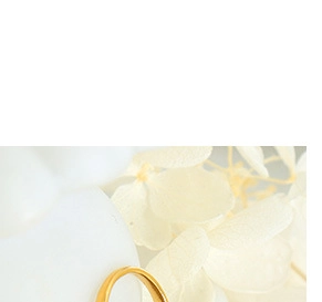 Macro shot of a vintage gold-plated C-shaped ring with a floral background detail