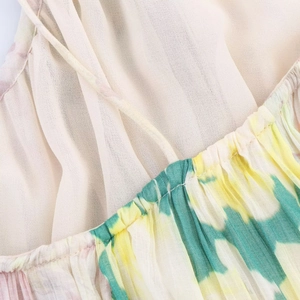 Dettaglio del tessuto in chiffon a fiori gialli con cuciture a pieghe e laccetto
