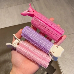 Set of pink and purple hair root volume clips for natural hair lift and styling