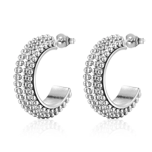 Boucles d'oreilles créoles argentées en C avec texture perlée sur fond blanc pur