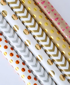 Macro detail of high-quality gift wrapping paper rolls with gold foil holiday patterns
