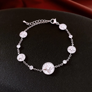 Close-up of silver adjustable bracelet featuring round star charms and zircon inlay