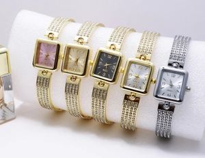 Close-up of five square quartz watches with rhinestones in various metallic finishes
