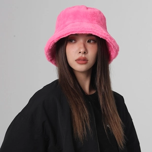 Front view of model wearing a fluffy pink faux fur bucket hat with soft plush texture