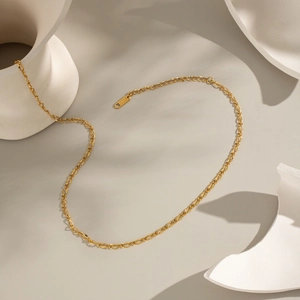 Minimalist 18K gold stainless steel chain necklace displayed on white ceramic