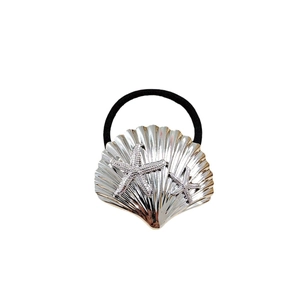 Silver shell hair tie with starfish detail and black elastic band on white backdrop