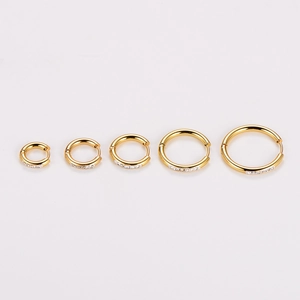Five gold-plated hoop earrings with sparkling crystal accents in various sizes