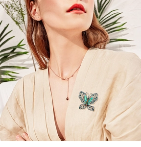 Detail of butterfly brooch with blue enamel and rhinestones on a blazer suit