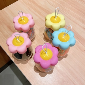 Macro view of colorful jelly hair ties in transparent jars with sunflower lids