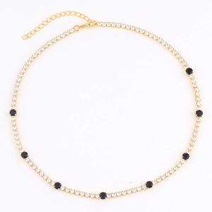 Detailed close-up of gold-plated tennis necklace with black and white cubic zirconia stones