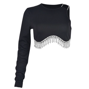 Détail d'un crop top noir en maille côtelée avec ourlet élégant en franges de strass argentés