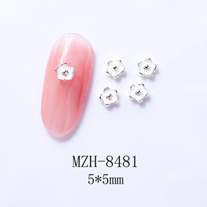Close-up of 5mm white and silver 3D five-petal alloy nail charms with oil-drop finish