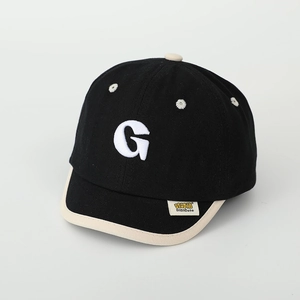 Detail of white towel embroidery letter G on kids black canvas short brim baseball cap