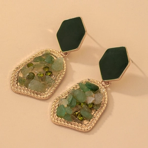Detail of vintage geometric earrings with green crushed stone and irregular gold frame