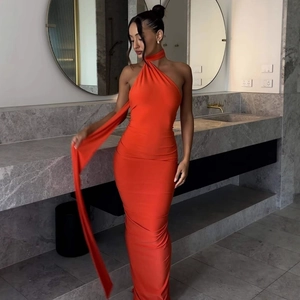 Detail of a sexy orange backless halter dress with long ribbons in a modern setting