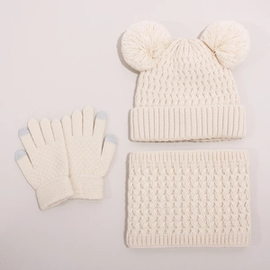 Detail of knit beanie with pom-poms, matching scarf and touchscreen gloves set