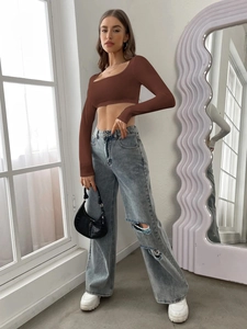 Brown long sleeve cropped top paired with light blue distressed wide leg jeans and sneakers