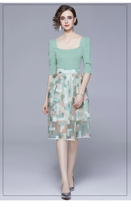 Detail of green square neck knit top paired with geometric mesh fairy midi skirt