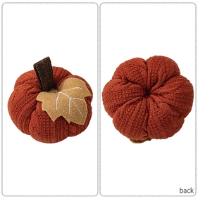 Detail of knitted orange pumpkin with brown stem and felt leaf showing front and back view