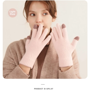 Close-up of light pink knitted gloves showing touch screen tips and diamond pattern weave