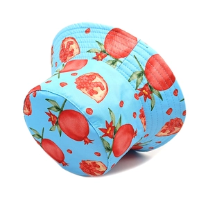 Close-up of light blue sun hat with realistic red pomegranate and green leaf prints
