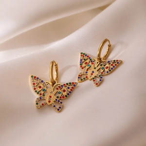 Detail shot of butterfly earrings with 18K gold plating and colorful zircons on silk fabric