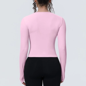 Détail du haut de yoga rose à manches longues, coupe ajustée et tissu respirant de qualité