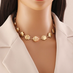 Elegant gold scallop shell link necklace displayed on a beige suit mannequin