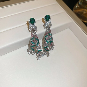 Detailed macro view of silver drop earrings with green and pink crystal tassels