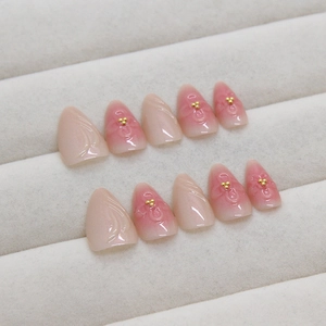 3D peach blossom press-on nails with pink blush gradient and golden beads on almond shape