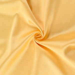Macro view showing the champagne gold satin fabric with luxurious glossy texture and folds
