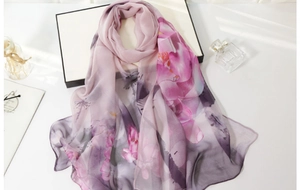 Detail of elegant floral silk scarf with soft watercolor prints on lightweight chiffon fabric
