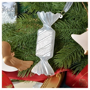 Ornamento a forma di caramella glitterata argento appeso a un ramo di Natale
