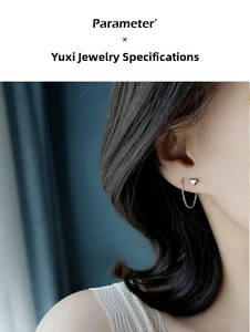Detail of silver heart-shaped ear threader on model, minimalist sleek drop earring design