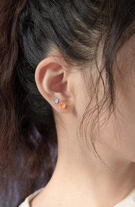 Close-up of blue and orange flower earrings with 925 silver needles worn by model