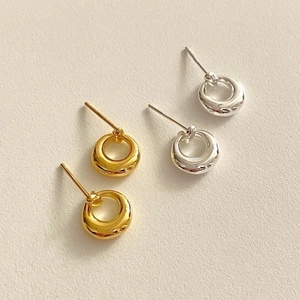 Macro detail of minimalist S925 sterling silver hollow round stud earrings in gold and silver