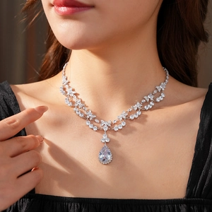 Detailed close-up of a pear-cut zircon pendant with double-layered silver-tone necklace chain