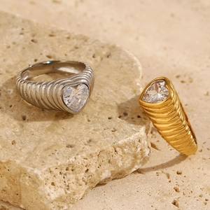 Macro detail of heart-shaped zircon rings with unique twisted band texture in gold and silver