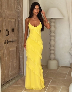 Detailed view of yellow tiered ruffle maxi dress with thin straps in a luxury setting
