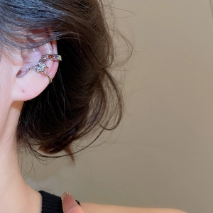 Close-up of butterfly ear cuff and colorful gemstone band on a model's ear